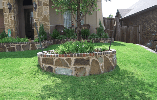 Hardscape - stone planter in front of house