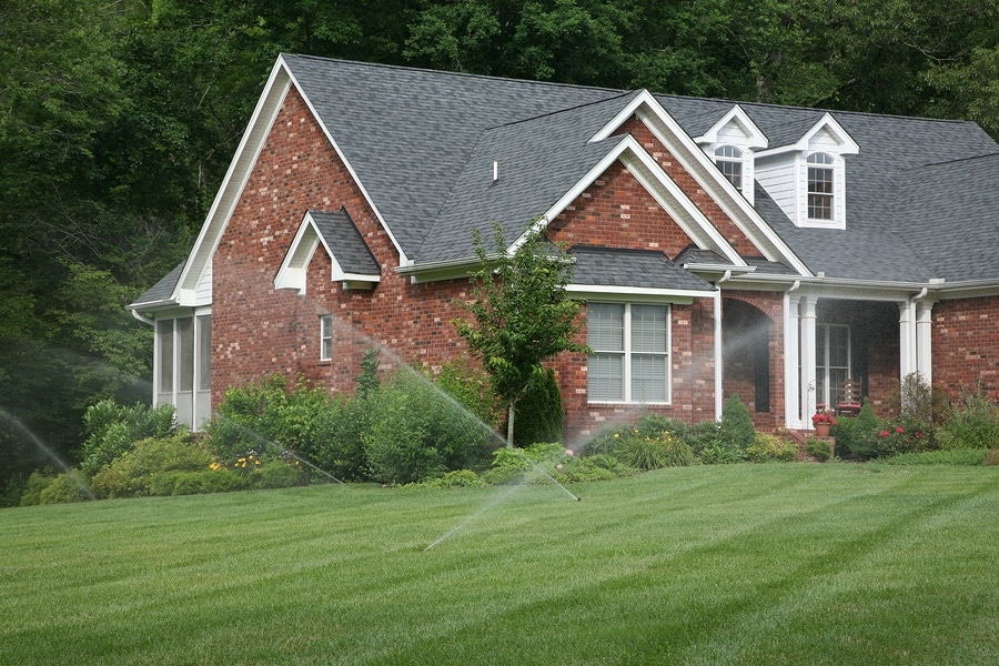 sprinkler system - sprinklers watering lawn in front of house