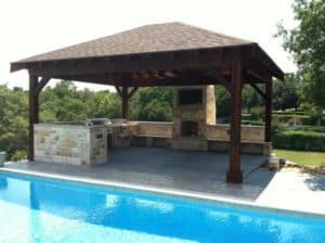 outdoor space - wood pergola with stone outdoor kitchen near pool