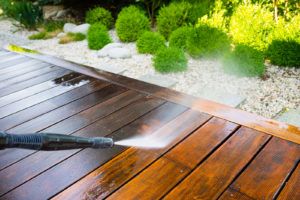 hardscape construction - person power washing wood deck