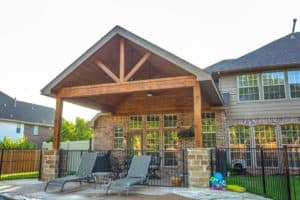 outdoor living spaces - wood patio cover next to pool and pool chairs