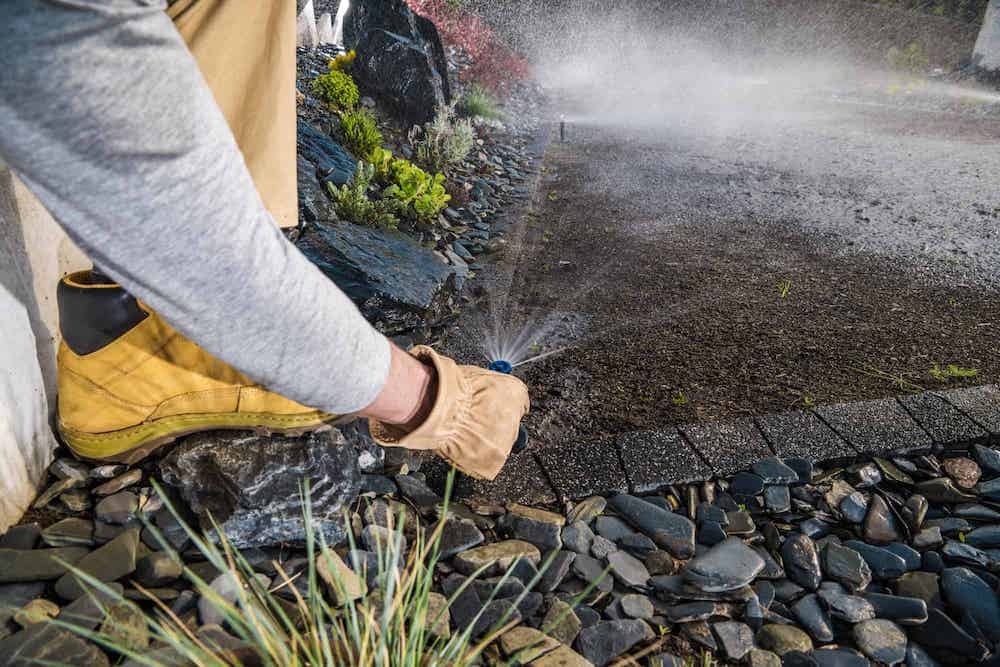 landscaping-worker-adjusting-garden-water-sprinkler